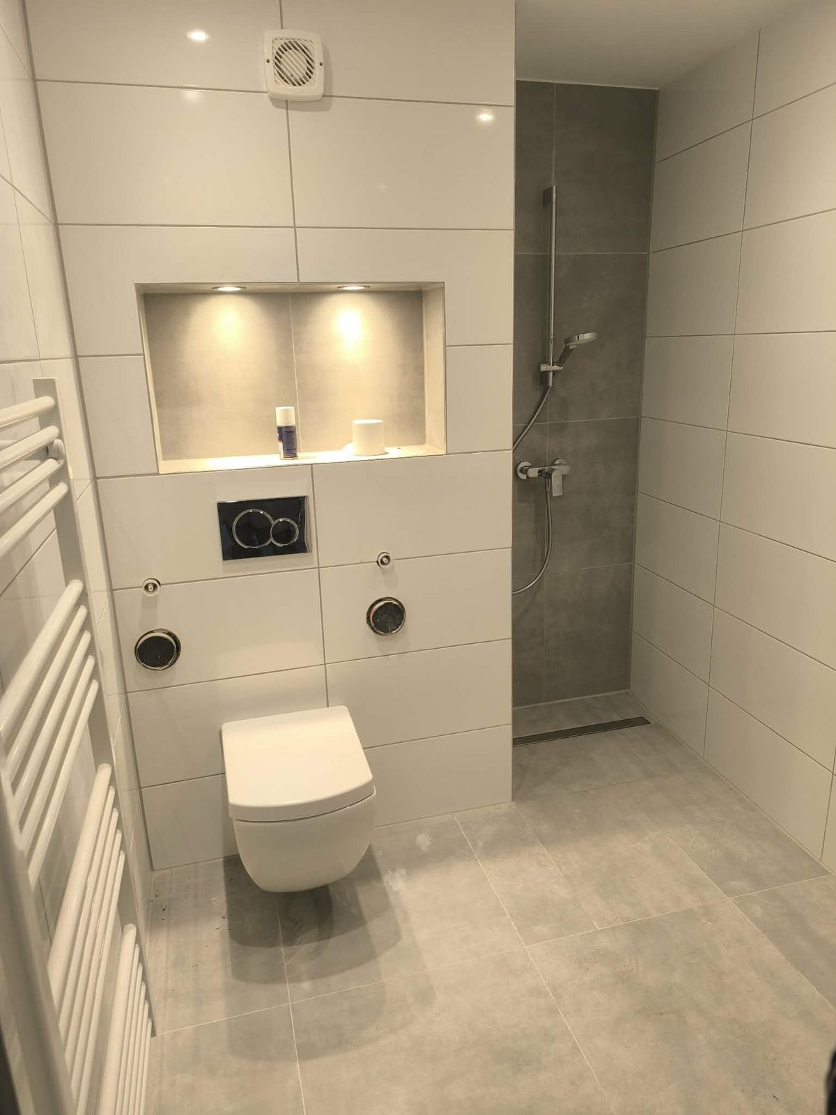 Badsanierung Peine – Vorwandinstallation mit beleuchteter Nische, Wand-WC und Dusche in Betonoptik